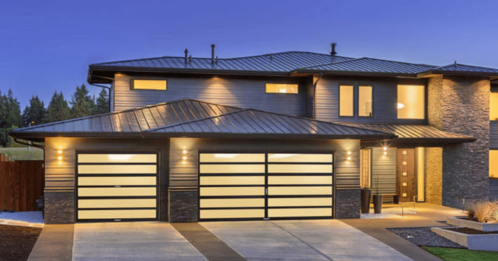 Modern house with illuminated garage doors.