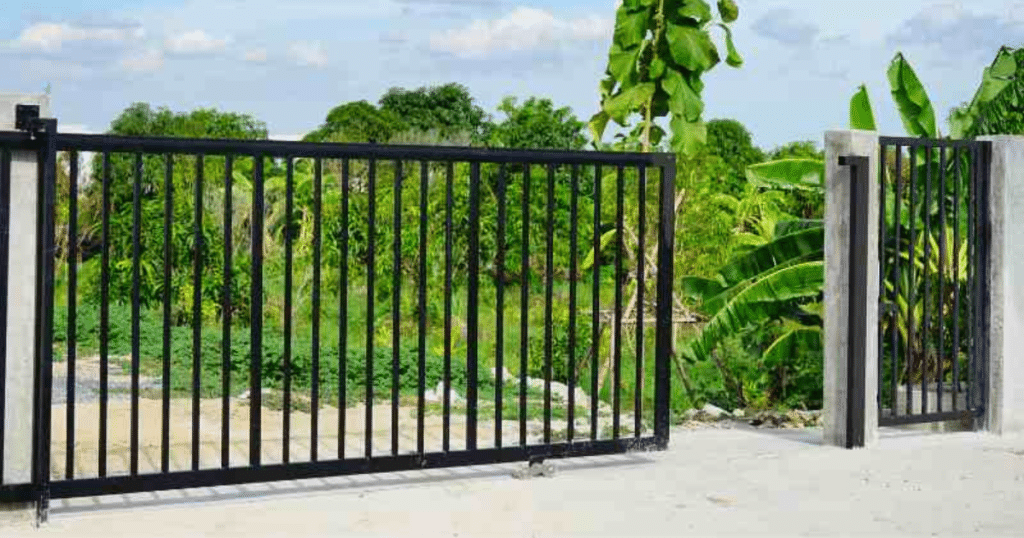 Black sliding gate on a concrete driveway.