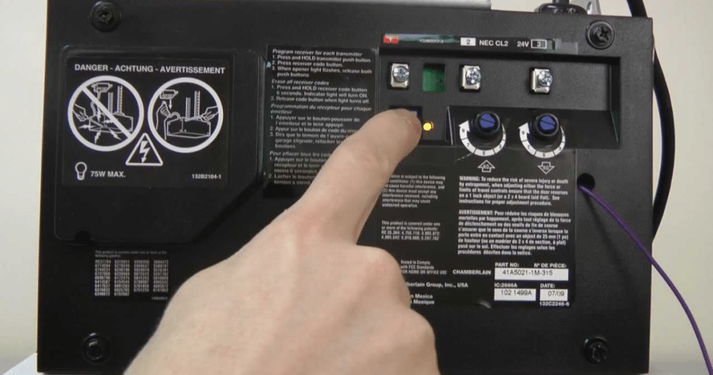 Finger pressing button on garage opener.